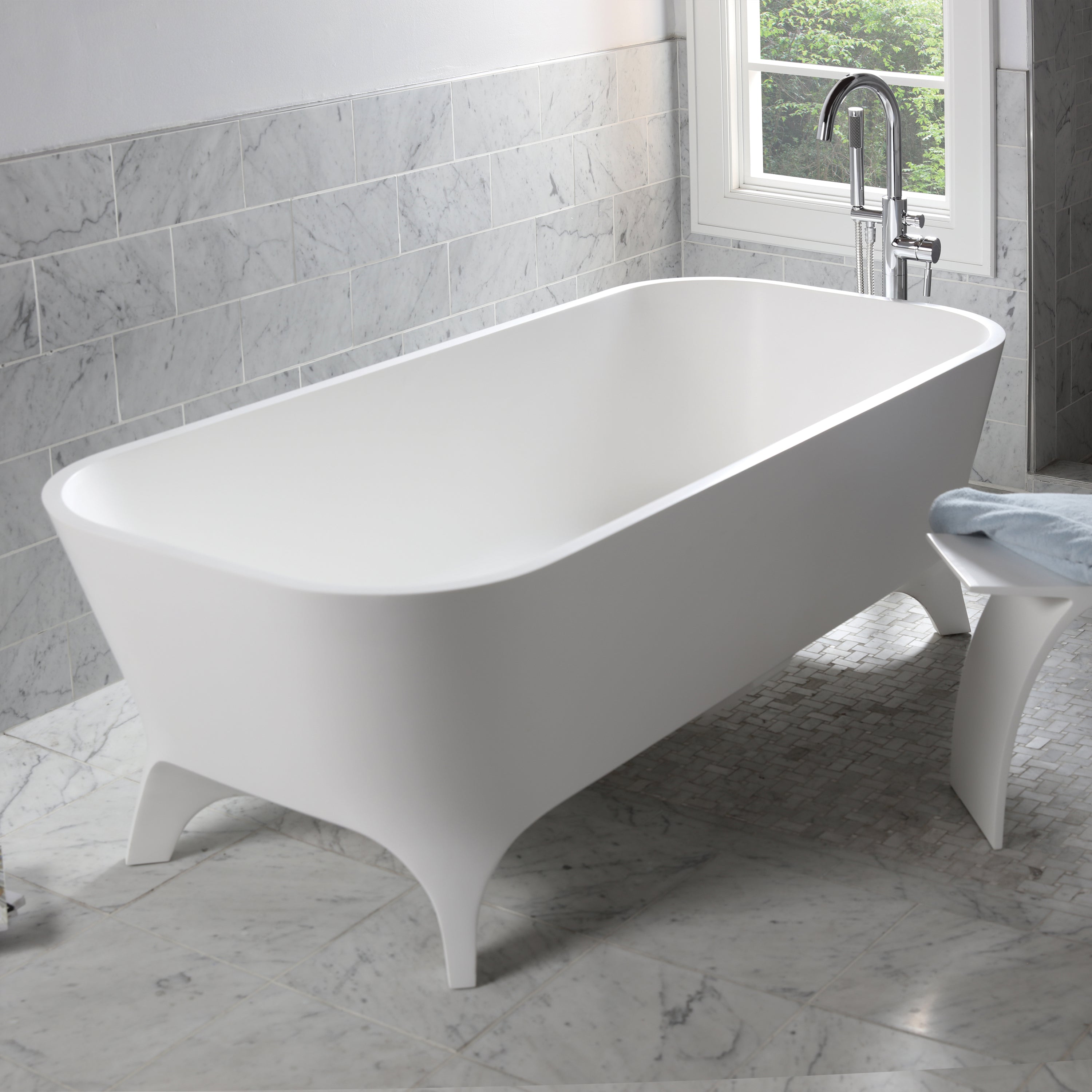 Free-standing soaking bathtub made of white solid surface with an overflow and a decorative solid surface drain; net weight 408 lbs, water capacity 91 gal. W: 70 7/8", D: 31 1/2", H: 23 5/8".